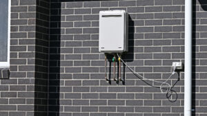 Instantaneous tankless gas hot water heater on the side of a building
